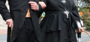 Two people in black heritage clothing. 