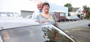 Two commuters who carpool stand outside their car.