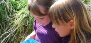 Two girls looking at something in their hands. 