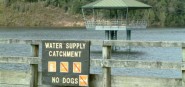 A fence in front of a water catchment. 