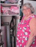 A woman in front of a hot water cylinder. 