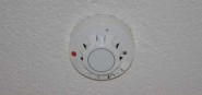 A fire alarm unit on the ceiling. 