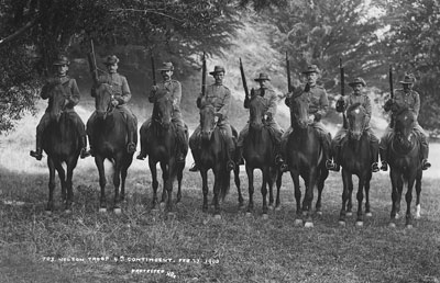 A black and white image of riders on horseback. 