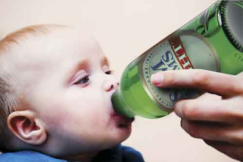 baby being fed beer from bottle.  