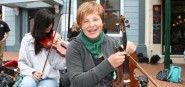 A girl sitting with a violin. 