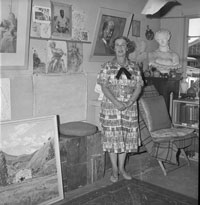 Photo of Marjorie Naylor standing among pieces of art. 