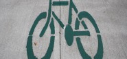 A painted green bike on a footpath. 