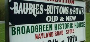 An event sign posted on a green lawn. 
