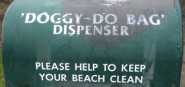 A green dispenser of doggy do bags. 