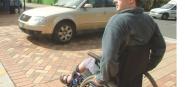 A man in a wheelchair crossing the street. 