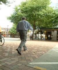 A pedestrian using a brick paved courtesy crossing.  
